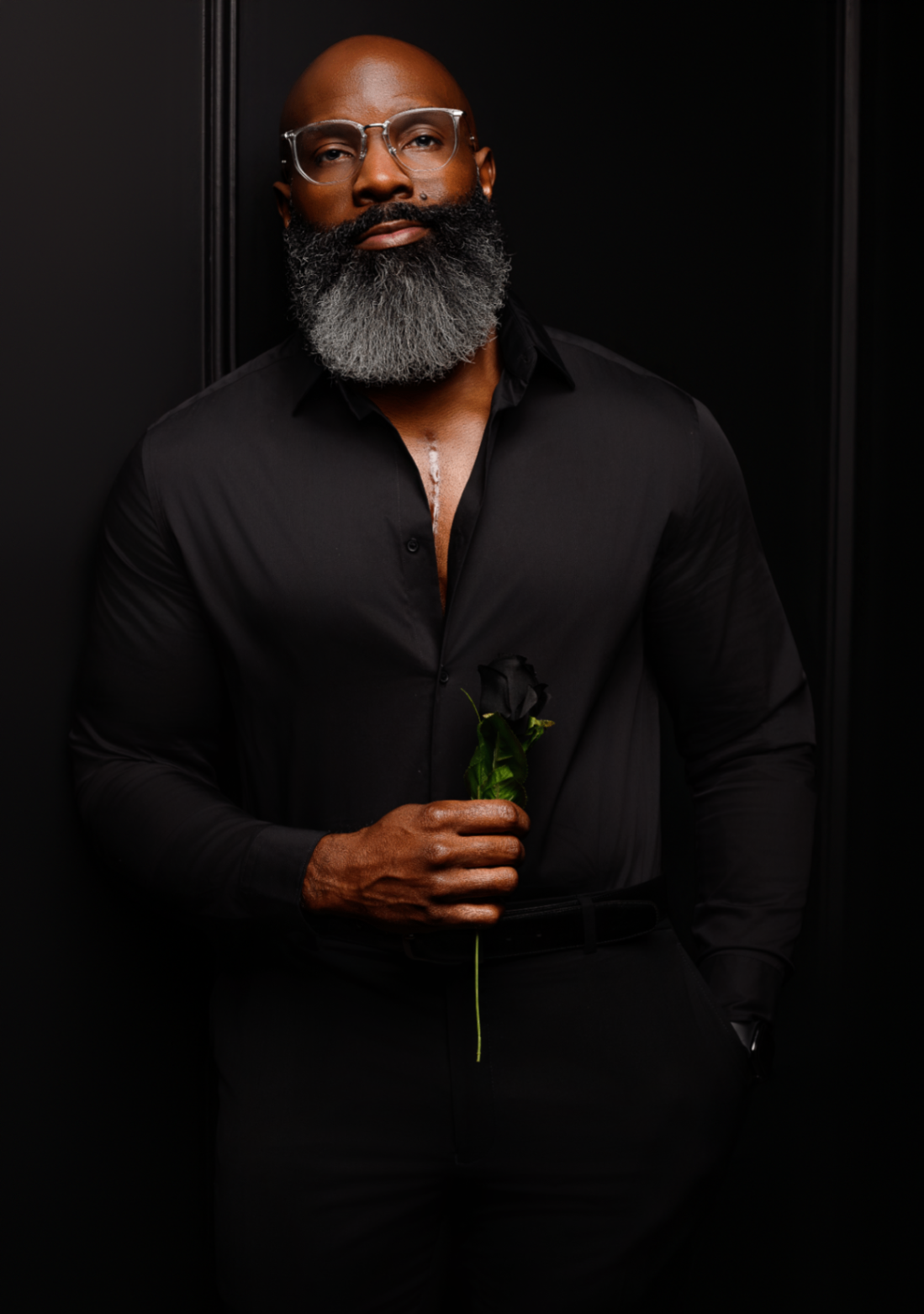 Dramatic black-on-black portrait with rose